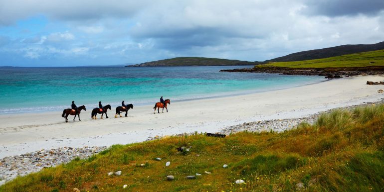 Horse and riders on the beach